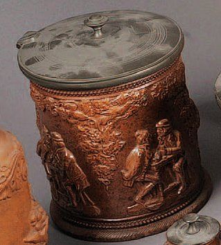 EST Pot à tabac en grès à vernis salin à fond brun décoré en relief de personnages...