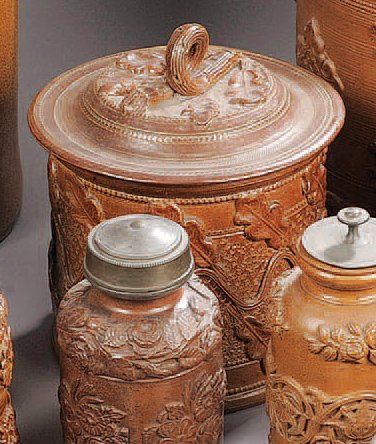 EST Pot à tabac cylindrique couvert en grès à fond brun décoré en relief de glands...