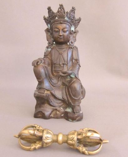 null Buddha en bronze à patine brune assis en lalitasana sur un rocher, la main gauche...