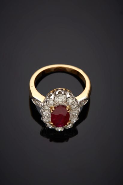  Yellow and white gold (750‰) oval "daisy" ring set with a ruby weighing 1.48 carats,...