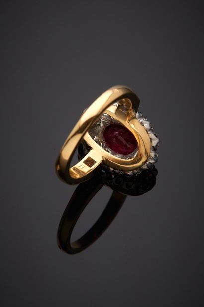  Yellow and white gold (750‰) oval "daisy" ring set with a ruby weighing 1.48 carats,...