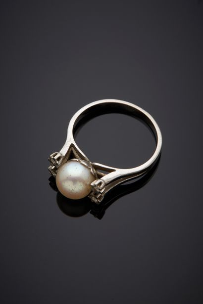  White gold ring (750‰) set with a white cultured pearl, shouldered by four small...