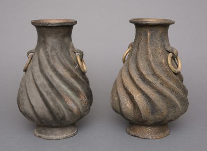 Pair of metal vases with rough surface in...