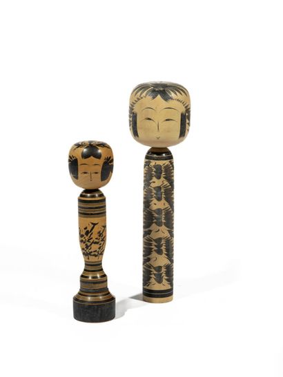 Two large wooden kokeshi dolls painted with...