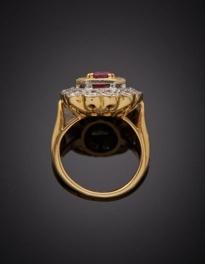  Yellow and white gold (750‰) "daisy" ring set with an oval ruby, within a double...
