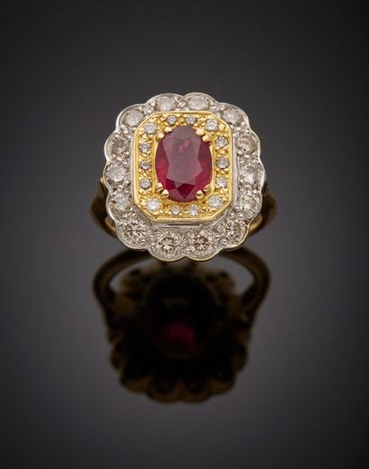  Yellow and white gold (750‰) "daisy" ring set with an oval ruby, within a double...