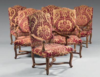 null Suite de six fauteuils en bois naturel mouluré et sculpté d'agrafes feuillagées....