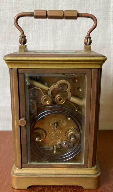 null Travelling clock, the bronze cage mount surmounted by a plug. H. : 15 cm. L....
