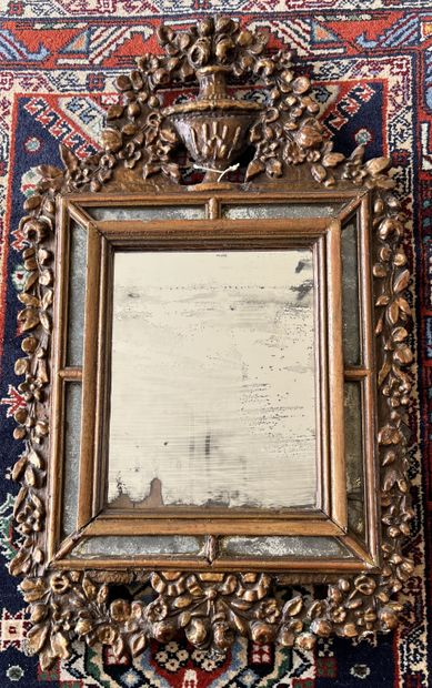 null Mirror with a gilded wood frame decorated with friezes and garlands of flowers....