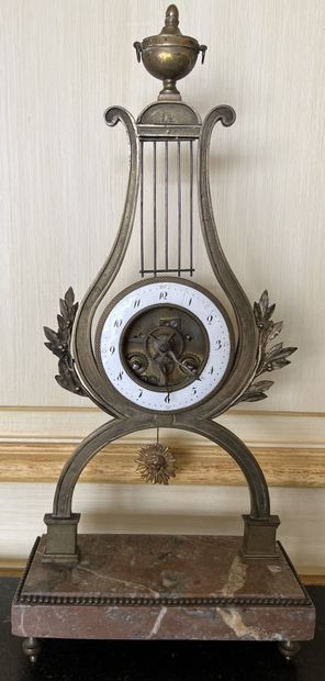null Skeleton clock in bronze the white enamelled dial in a lyre surmounted by an...
