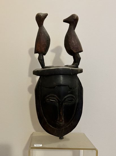 null Masque africain en bois sculpté surmonté de deux volatiles. H. 35 cm - L. 14...
