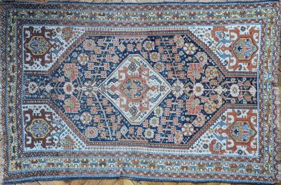 null Oriental wool carpet, decorated in the center with a lozenge with pendants,...
