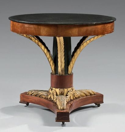  Table in mahogany veneer and carved and gilded wood; the belt supported by palms...