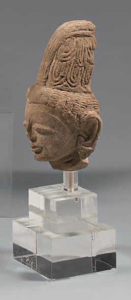 INDE Fragment de bas-relief, tête de divinité en grès gris, la coiffe ramassée en...