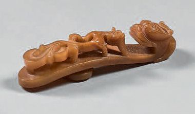 CHINE Honey-coloured agate fibula, with carved decoration in high relief and detached...