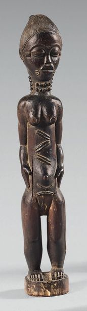 null Baule Statuette. (Côte d'Ivoire). The female subject is depicted standing with...