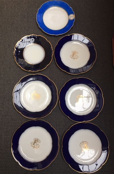 LIMOGES Fourteen flat plates with various decorations on a blue border surrounded...