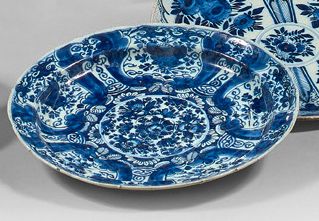 DELFT Two plates, one of which has a contoured earthenware rim decorated with blue...