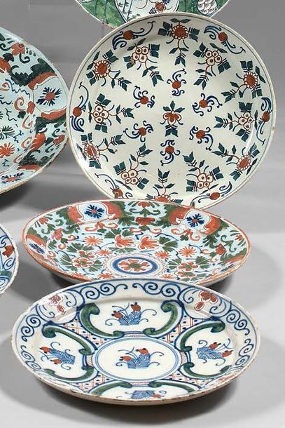 DELFT Three earthenware plates with polychrome decoration of different flowers. XVIIIth...