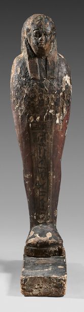 Figure of a mummiform Ptah Osiris adorned with a long tripartite wig. A column of...