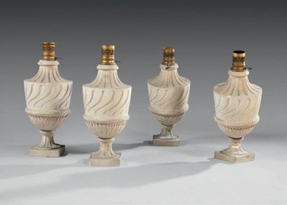 null A suite of four reconstituted stone gas lamps in the form of vases with torsos,...