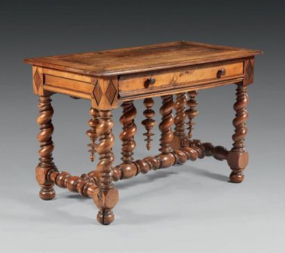null Moulded or turned walnut table; rectangular in shape, it opens with a wide drawer...