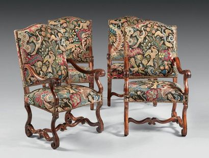 null A suite of four high-backed, flat, moulded walnut armchairs with winding armrests...