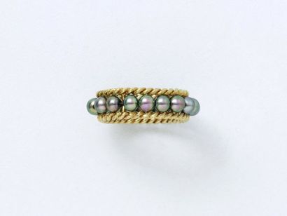 null 750 thousandths gold ring, decorated with a row of grey cultured pearls bordered...
