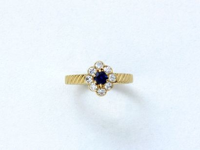 null Bague en or 750 millièmes, stylisant une fleurette ornée d'un saphir rond facetté...