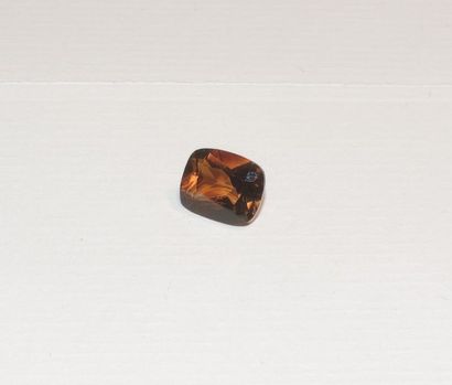 null A facetted topaz cut into a rectangular cushion, orange-brown in colour. Dimensions:...