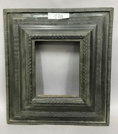null Moulded and blackened satin frame with an upside-down profile and guillloched-rod...