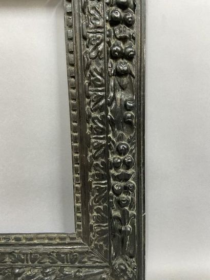 null Natural wood frame, blackened with a floral and foliage frieze, putti heads...