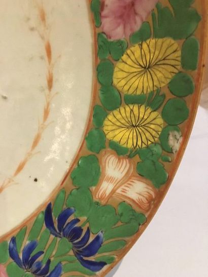 null CHINE. 

Paire de plats creux en porcelaine à décor polychrome de la famille...