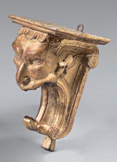 null Carved and gilded wooden wall console in the form of a grotesque head flanked...