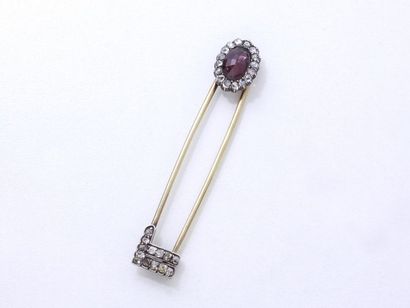 null Gold 585 and silver 800 thousandths safety pin dressed with a faceted garnet...