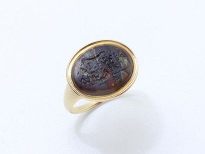 null A 750 thousandths gold signet ring set with an oval intaglio on glass paste...