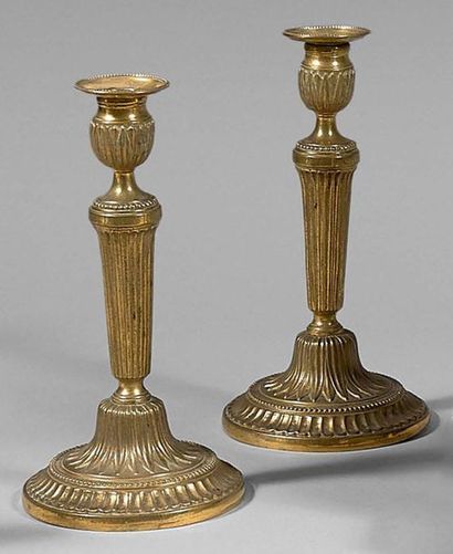 null Pair of chased and gilded bronze candleholders; binets with rows of pearls;...