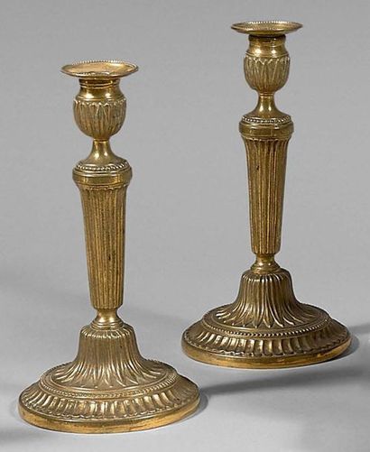 null Paire de bougeoirs en bronze ciselé et doré ; les binets à rangs de perles ;...