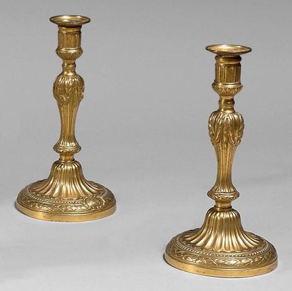 null Pair of candlesticks in chased and gilded bronze; the bobèches with canals and...