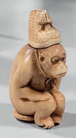 JAPON Carved ivory Netsuke representing a monkey wearing an eboshi sitting on a wicker...