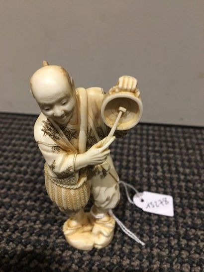 JAPON Two ivory okimono, one a peasant standing with a basket hanging from his shoulder...