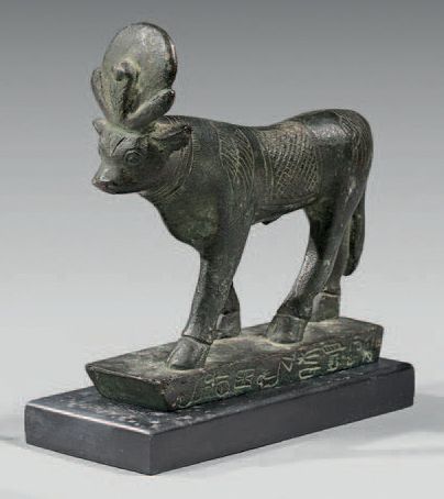 null Lot comprising an Apis bull walking on an inscribed base of pseudo hieroglyphics....