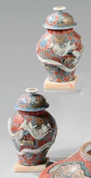 JAPON Pair of small covered porcelain vases decorated in light relief with dragons...