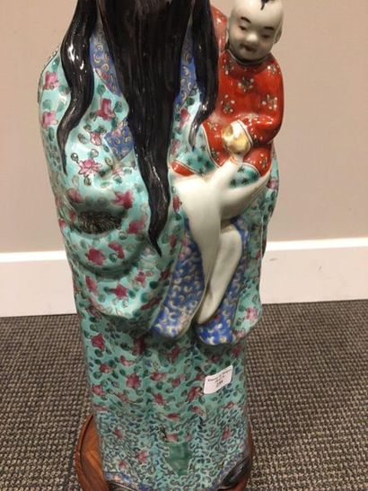 CHINE Large porcelain figurine representing a mandarin holding a child in his arms,...