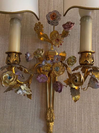 null Three ormolu sconces with two light arms decorated with porcelain flowers 

Louis...