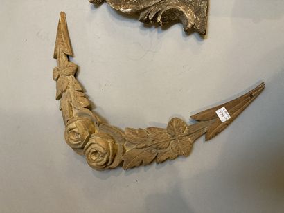 null Two carved wooden elements, one decorated with a garland of flowers, the other...