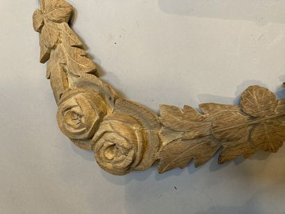 null Two carved wooden elements, one decorated with a garland of flowers, the other...