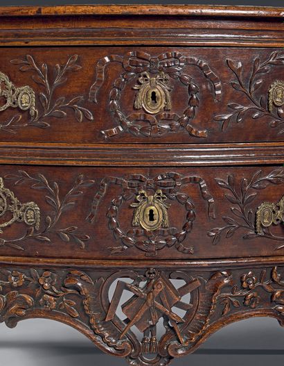  A moulded and carved walnut chest of drawers decorated with laurel branches and...