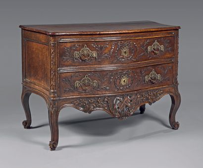  A moulded and carved walnut chest of drawers decorated with laurel branches and...