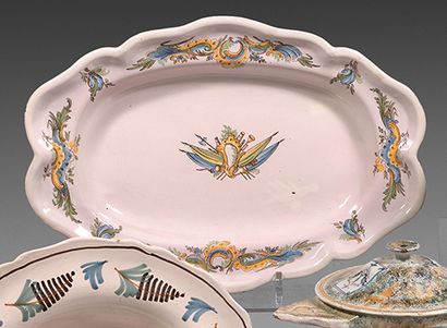 MOUSTIERS Oval earthenware dish with contoured border decorated with trophies and...